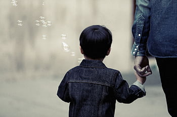 A child and adult walking together holding hands, evoking family bond and care. HD wallpaper