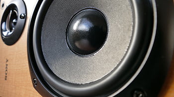 Detailed close-up of a modern speaker woofer cone showing texture and design. HD wallpaper