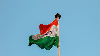 Indian national flag waving proudly against a clear blue sky in Jaipur, symbolizing patriotism and unity. HD wallpaper