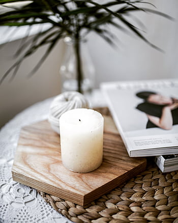 A calming still life with a candle, magazine, and plant on a textured surface indoors. HD phone wallpaper