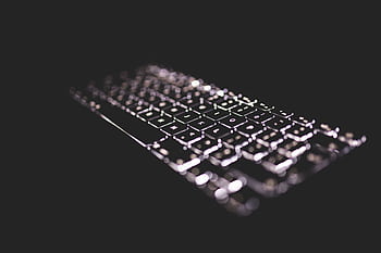 Close-up of a glowing keyboard with backlight on a dark background, emphasizing technology. HD wallpaper