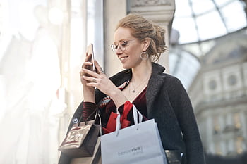 Stylish woman with shopping bags using smart in Milano, Italy. Perfect urban tech and fashion capture. HD wallpaper