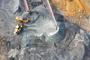 A top-down view showcasing mining operations with excavators and conveyor belts. HD wallpaper