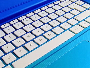 Detailed close-up of a white computer keyboard on a blue laptop. HD wallpaper