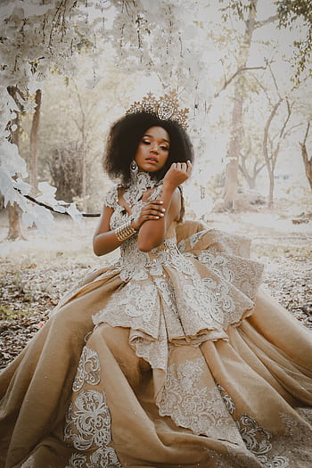 A beautiful bride in an ornate gown posing gracefully in a forest scene, exuding elegance. HD phone wallpaper
