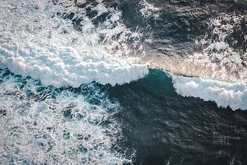 Captivating aerial view of ocean waves crashing in Bali, showcasing dynamic energy and natural beauty. HD wallpaper