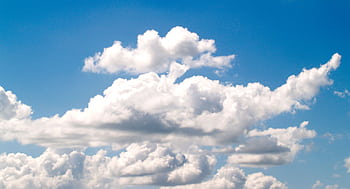 A scenic view of fluffy white clouds against a bright blue sky, perfect for backgrounds. HD wallpaper