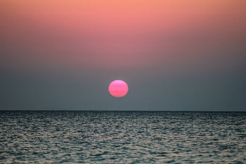 Peaceful ocean view with a vibrant sunset, perfect for a calming backdrop. HD wallpaper
