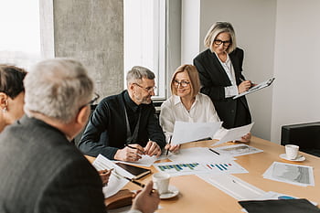 A diverse group of business professionals engaged in a strategic meeting. HD wallpaper