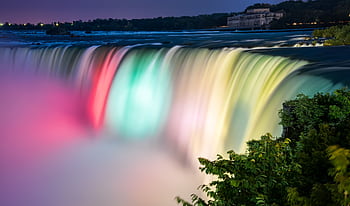 Stunning long exposure shot of Niagara Falls illuminated at night, showcasing colorful flowing water and mist. HD wallpaper