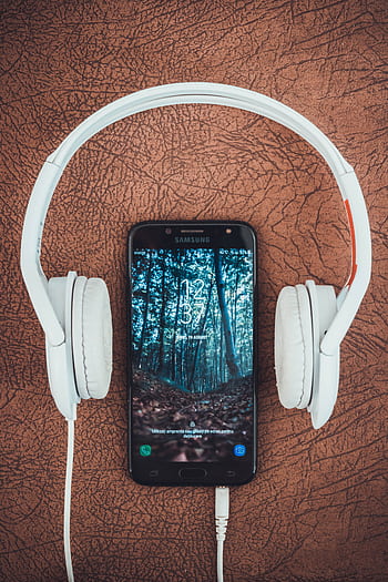 A smart paired with white heads on a brown textured surface, capturing modern tech vibes. HD phone wallpaper