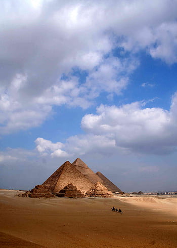 The iconic Pyramids of Giza stand majestically under a bright blue sky with scattered clouds. HD phone wallpaper