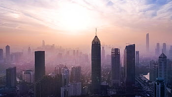 Stunning aerial view of Wuhan's skyscrapers enveloped in morning fog, capturing a serene urban landscape. HD wallpaper