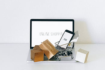 Display of online shopping theme with mini cart and payment devices on laptop. HD wallpaper