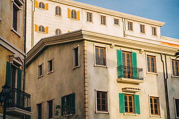 Charming urban architecture with colorful shutters and balconies under a clear blue sky. HD wallpaper