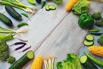 An assortment of fresh vegetables on a wooden table, perfect for healthy cooking. HD wallpaper