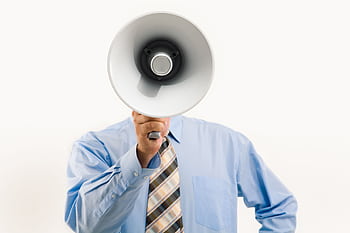 Businessman in blue shirt holding mega, symbolizing leadership and communication. HD wallpaper