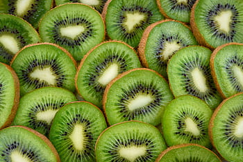 Vibrant, fresh kiwi slices arranged close-up, highlighting their juicy and nutritious appeal. HD wallpaper