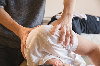 Close-up of a massage therapist working on a client's back in a wellness clinic. HD wallpaper