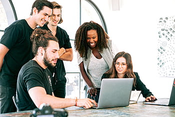 Dynamic team of young adults collaborating on project in bright modern office environment. HD wallpaper