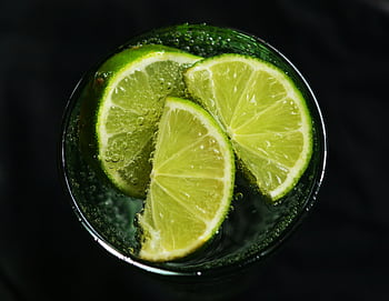 Close-up of fresh lime slices in a glass of sparkling water, refreshing concept. HD wallpaper