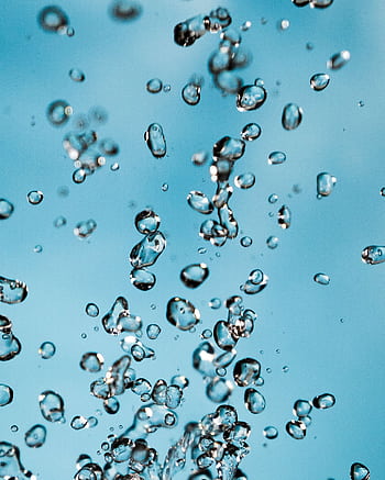 Vibrant capturing water droplets suspended against a bright blue sky background. HD phone wallpaper