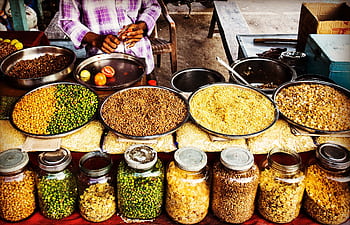 Colorful display of spices and legumes in a traditional Indian street market. HD wallpaper