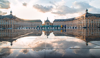 Breathtaking sunset reflection at Place de la Bourse, Bordeaux, France, showcasing historic architecture. HD wallpaper