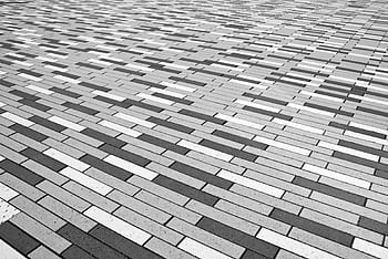 Abstract black and white patterned brick floor provides a geometric visual effect. HD wallpaper