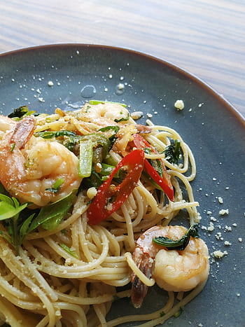 Appetizing shrimp pasta garnished with fresh chili and herbs in a close-up view. HD phone wallpaper