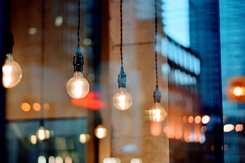 A creative shot of illuminated bulbs with city reflections, showcasing evening ambiance. HD wallpaper