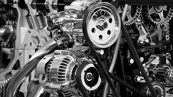 Close-up of a shiny car engine showing polished metal parts and gears in black and white. HD wallpaper