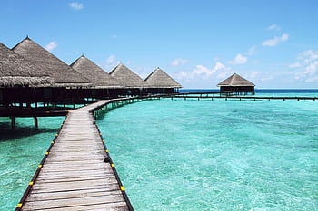 Scenic view of overwater bungalows on a tropical lagoon, perfect for a serene getaway. HD wallpaper
