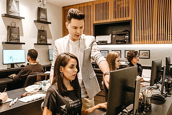 A diverse team collaborates in a modern office environment, fostering innovation and productivity. HD wallpaper
