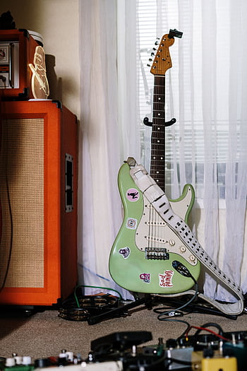 Stylish electric guitar with amp and equipment in a cozy home studio setting. HD phone wallpaper