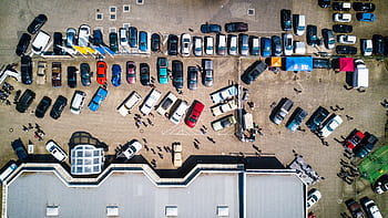 Drone shot showing cars and people in a parking lot in Rostock, Germany. HD wallpaper
