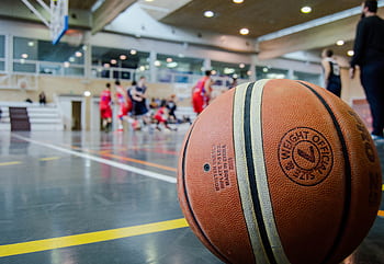 Captivating indoor basketball scene with players actively engaged in a game. HD wallpaper
