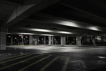 An empty urban parking garage at night with dramatic lighting creating a moody atmosphere. HD wallpaper