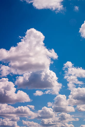 A serene view of fluffy white clouds floating in a bright blue sky on a clear day. HD phone wallpaper