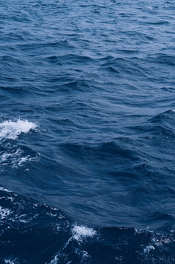 An expansive view of rolling deep blue ocean waves perfect for backgrounds or . HD phone wallpaper
