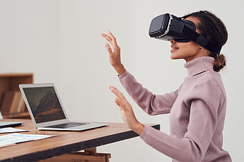 African American woman engaging with VR headset in indoor setting. HD wallpaper