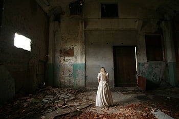 A woman in white stands in an eerie, abandoned building with decayed walls. HD wallpaper