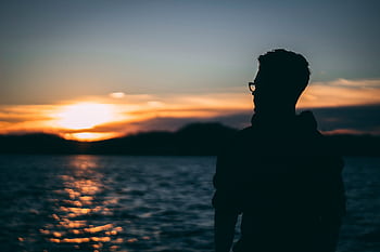 A silhouette of a man wearing glasses watching a beautiful sunset over Lake Ozark. HD wallpaper