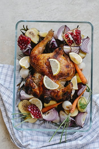 Deliciously roasted chicken topped with lemon slices, surrounded by fresh vegetables and pomegranate. HD phone wallpaper