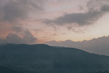 A peaceful view of Sri Lankan mountains during a stunning sunset with dramatic cloud formations. HD wallpaper