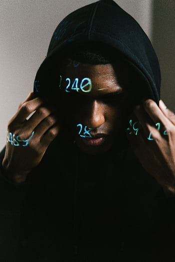 Person in black hoodie with digital numbers projected, creating a cybernetic ambiance. HD phone wallpaper