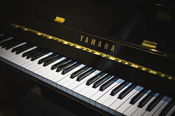 Close-up of a Yamaha piano showing black and white keys, perfect for music enthusiasts. HD wallpaper