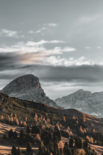 Breathtaking view of a mountainous landscape during winter with a dramatic sky. HD phone wallpaper