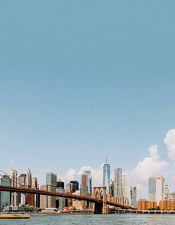 Captivating view of the Brooklyn Bridge and New York City skyline under a clear blue sky. HD phone wallpaper