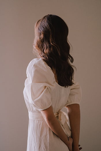 Back view of a woman in a chic white dress posing indoors with gentle light. HD phone wallpaper